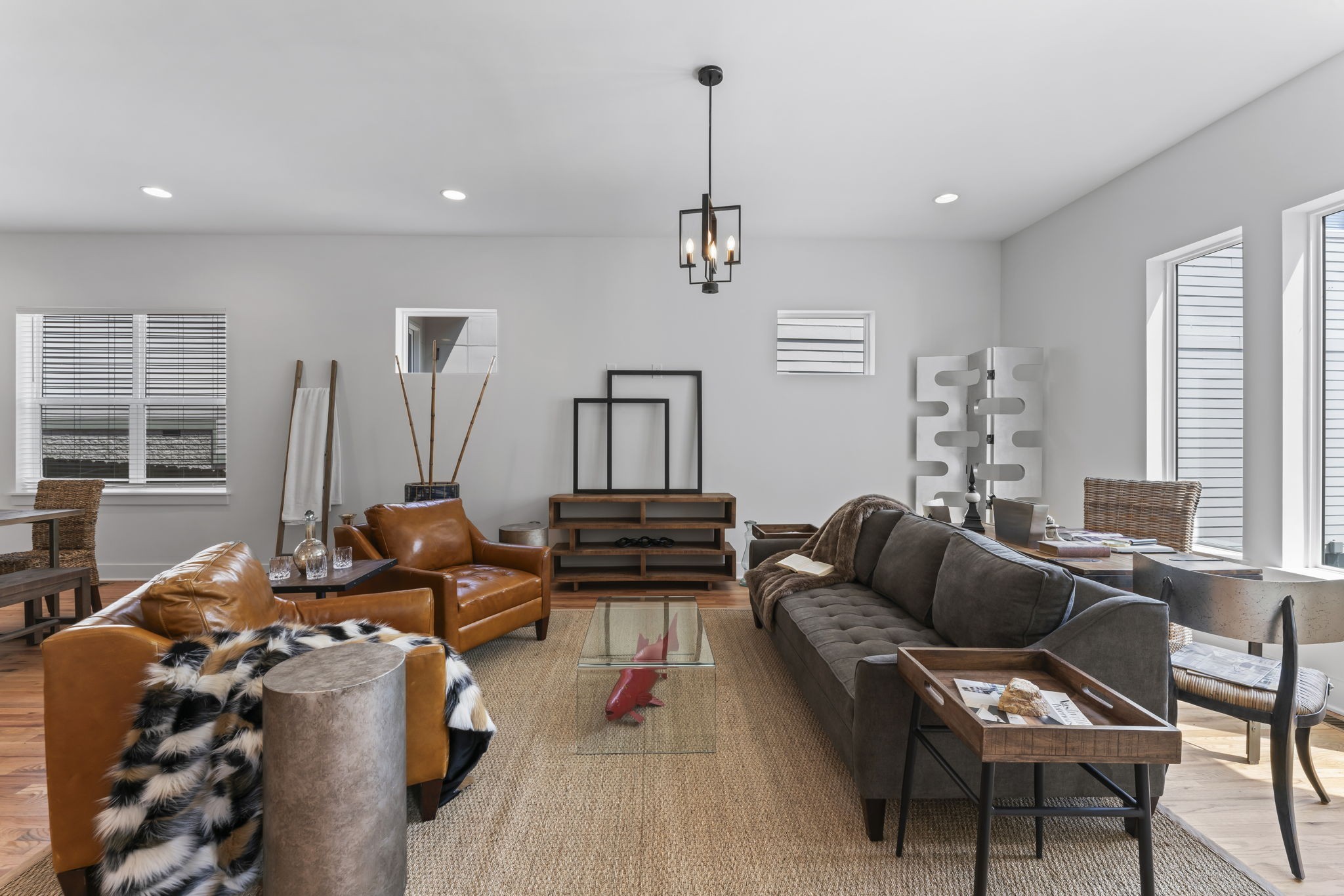 a living room with furniture a large window and a wooden floor