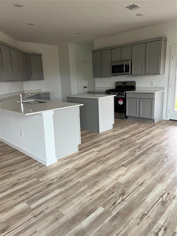 a large kitchen with cabinets and wooden floor