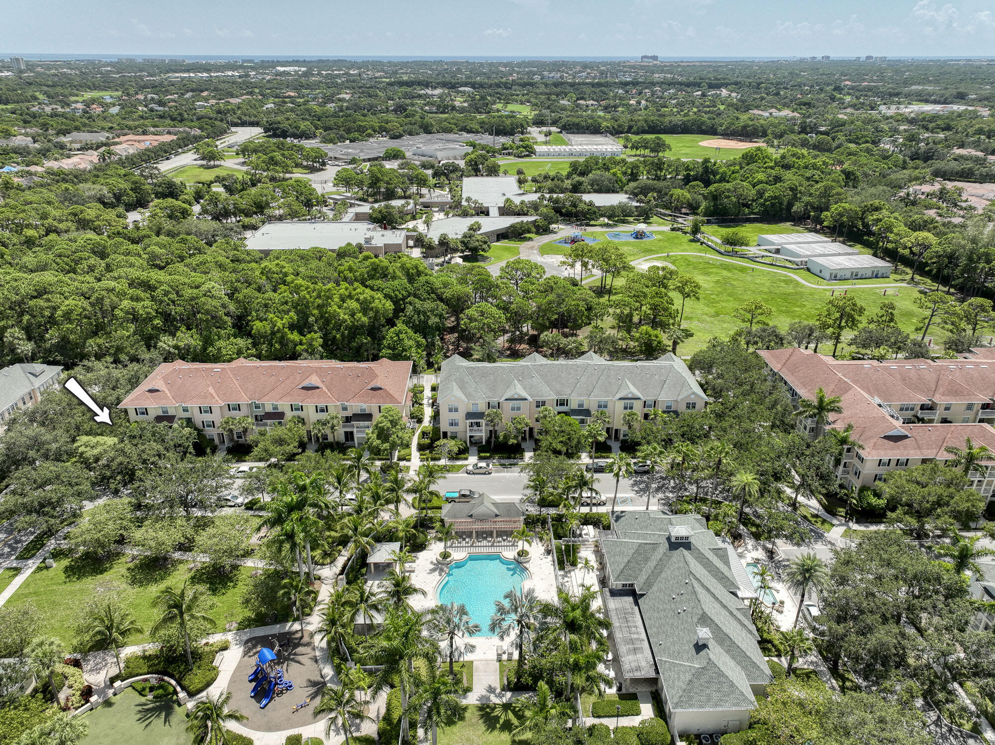 an aerial view of residential houses with outdoor space and trees