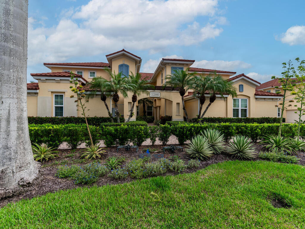 a front view of a house with a yard and potted plants