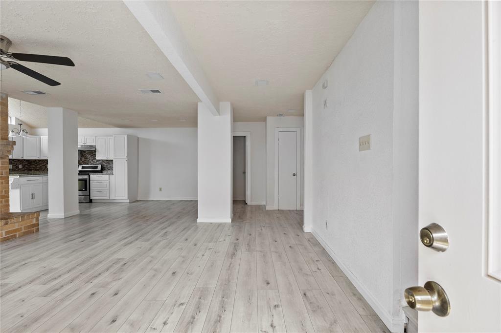 a view of empty room with wooden floor