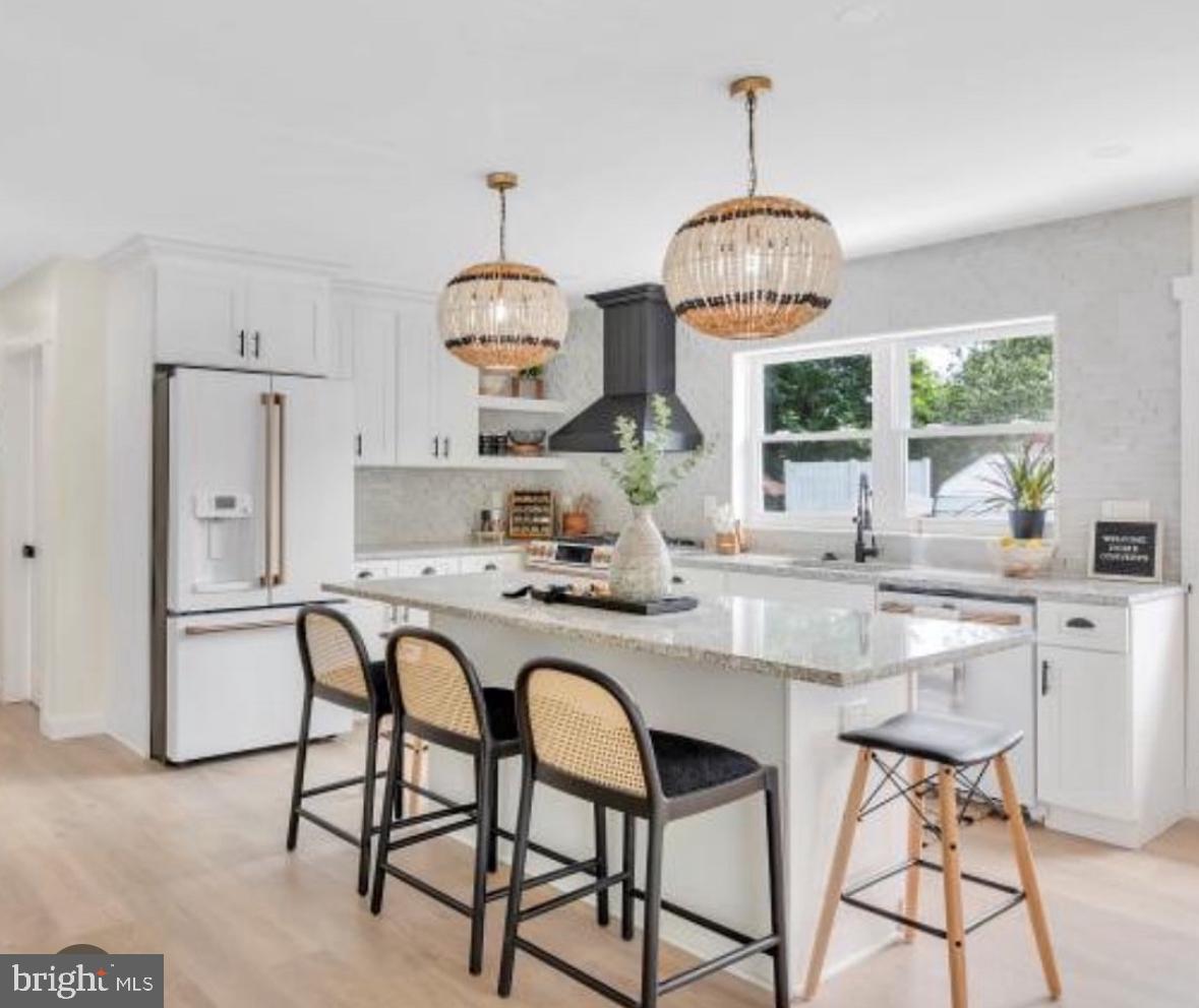 a dining room with furniture a chandelier and kitchen view