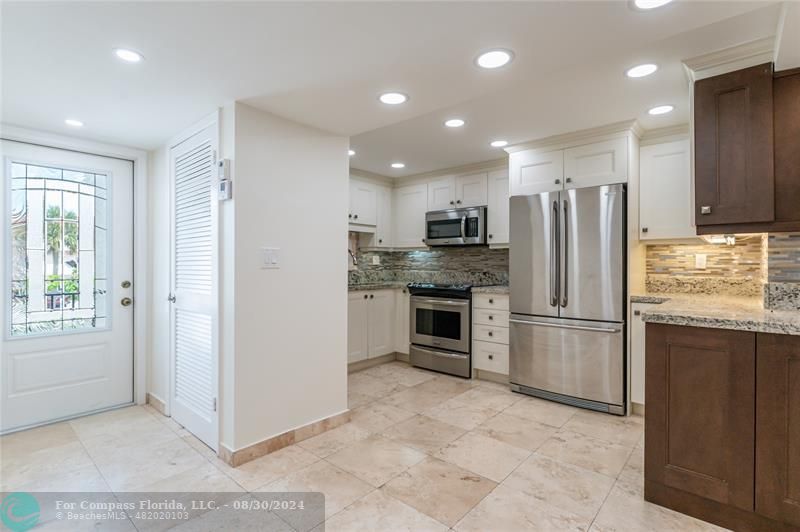 a kitchen with stainless steel appliances granite countertop a refrigerator and a stove top oven