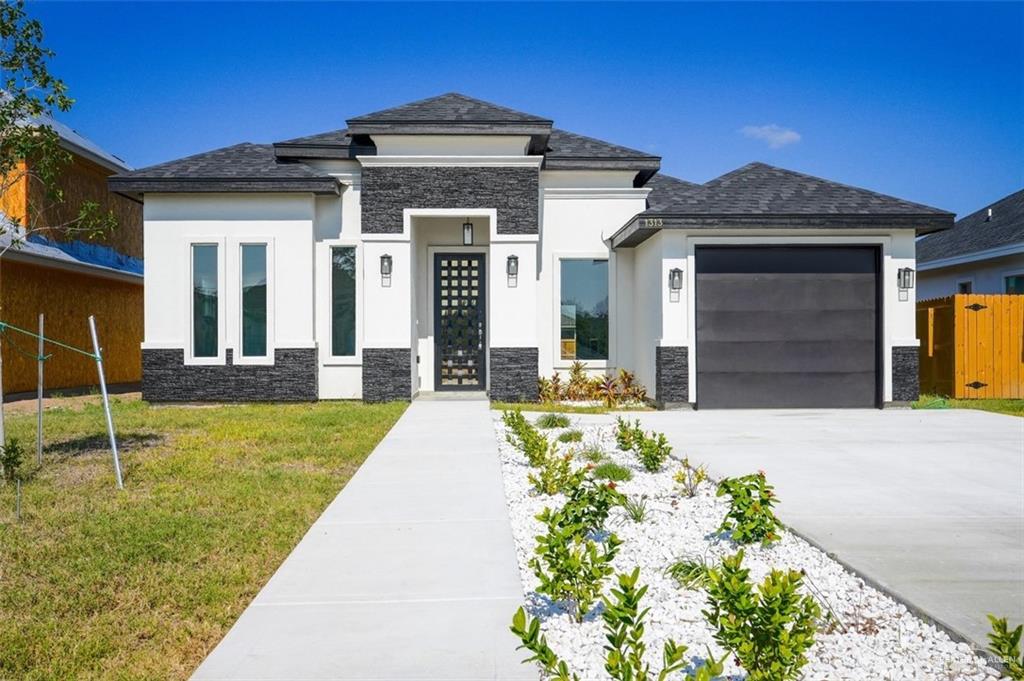 Prairie-style home with a garage and a front yard