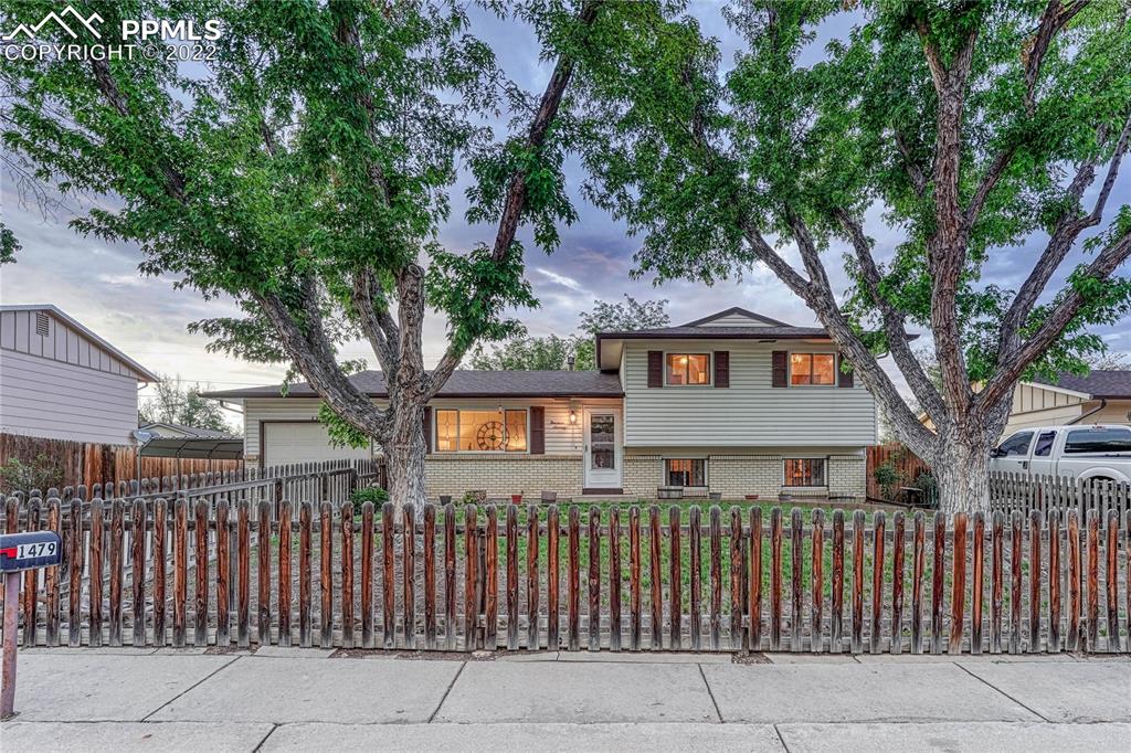 a front view of a house with a tree