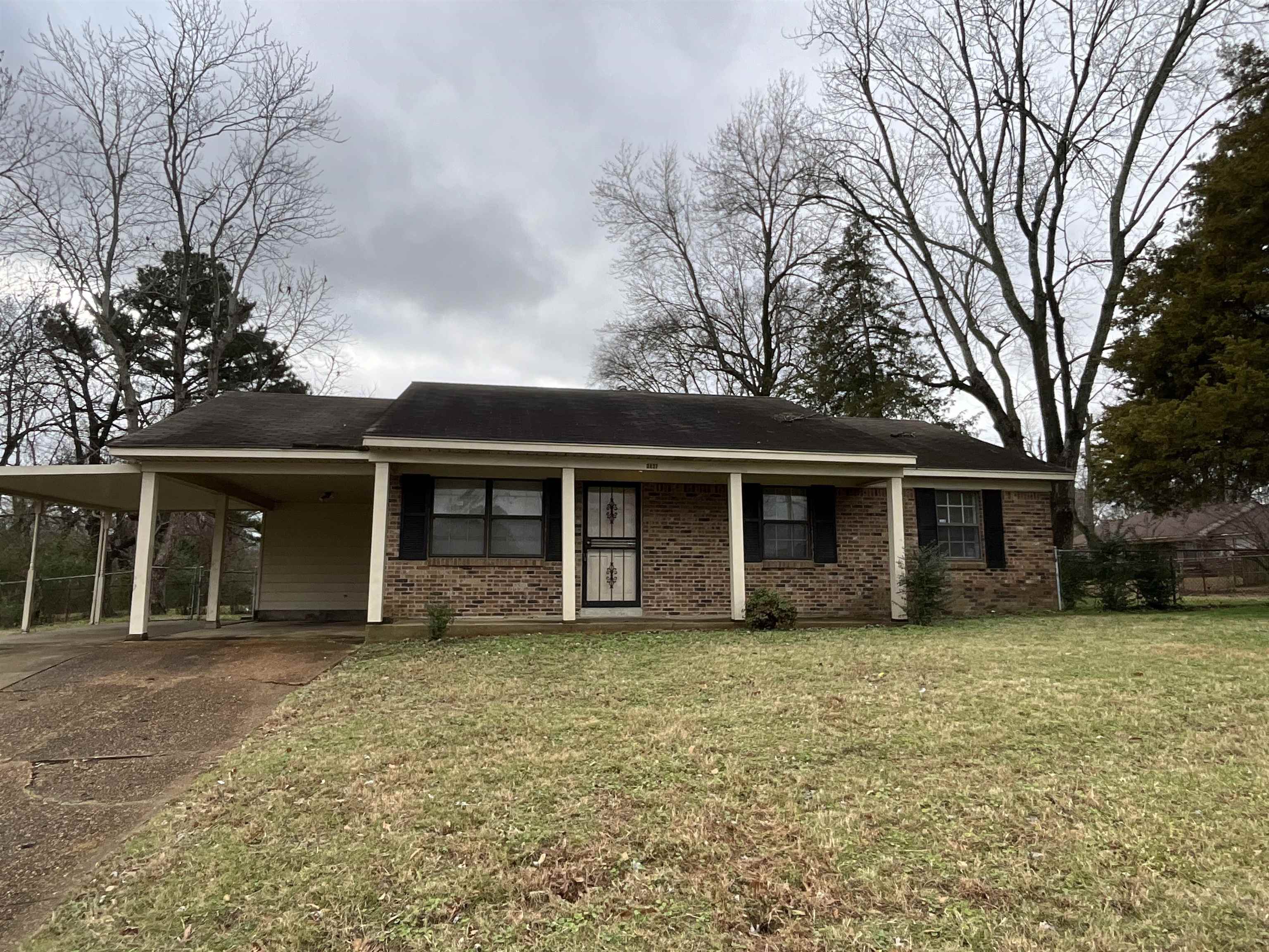 View of front of property with a front lawn and a carport