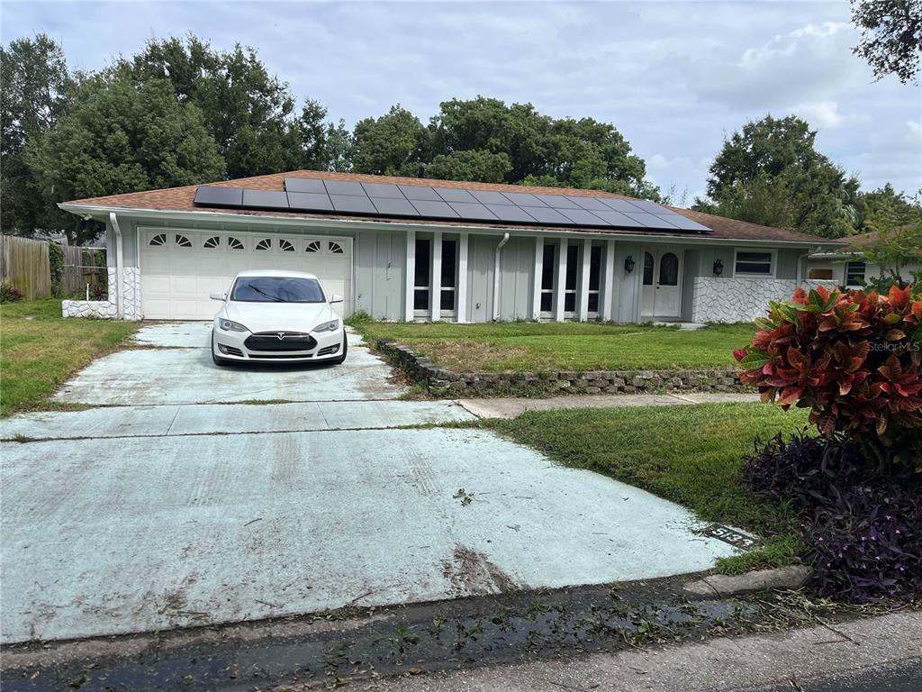 a front view of a house with a garden and yard