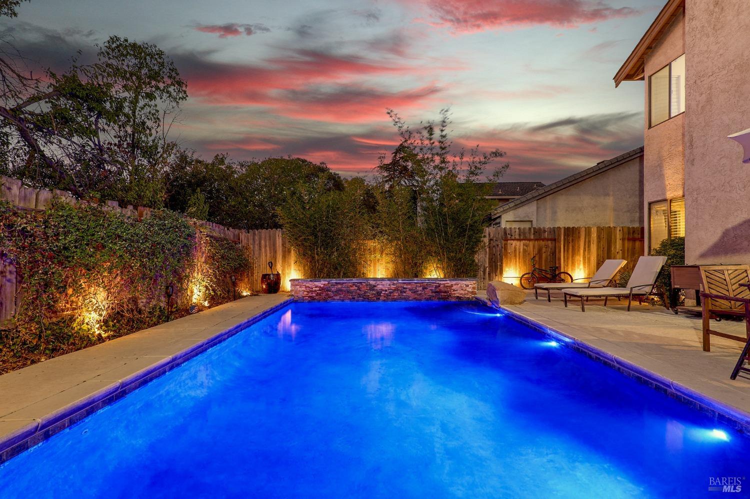 a view of swimming pool with outdoor seating and yard in back