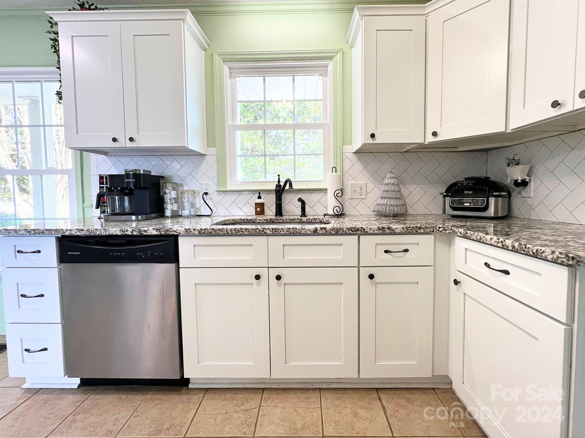 a kitchen with granite countertop white cabinets and white appliances