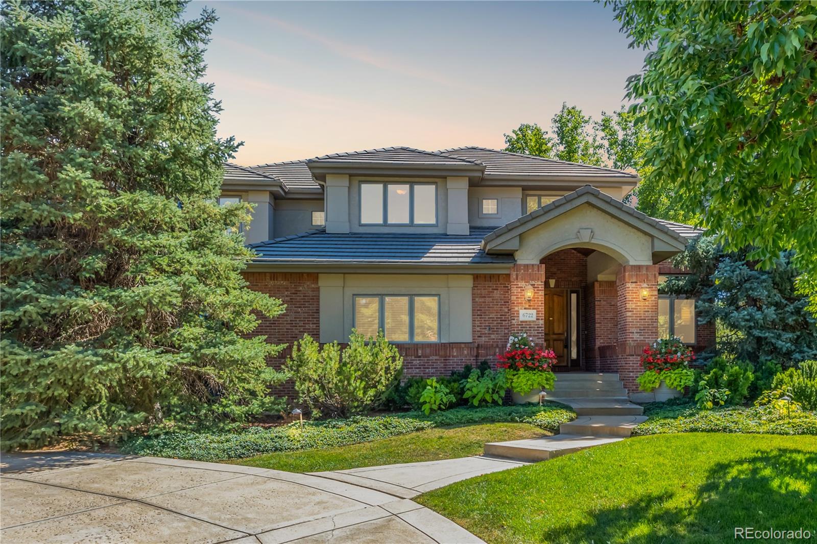 a front view of a house with a garden and plants