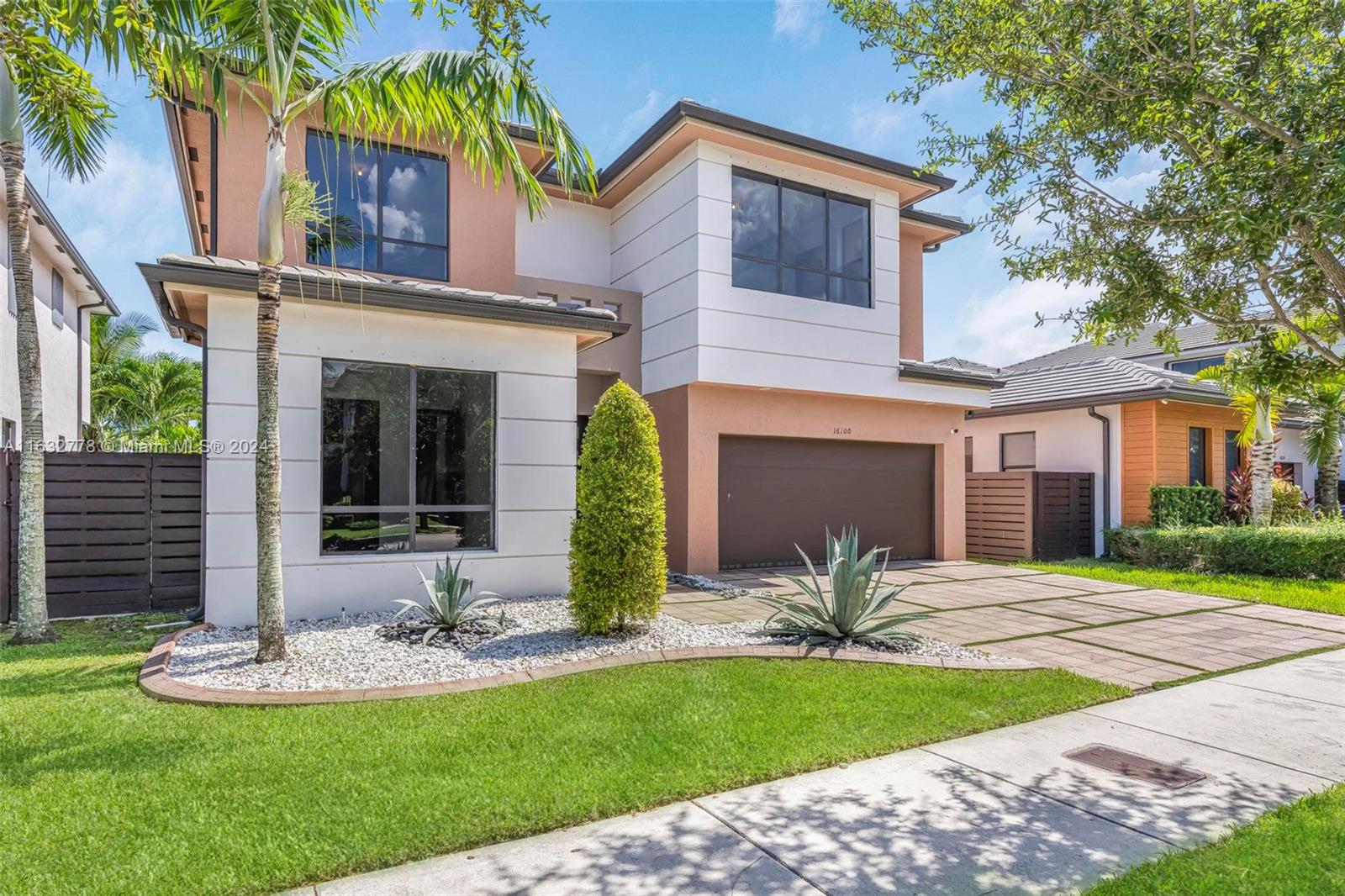 a view of a house with a yard and palm tree