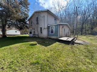 a view of a house with a yard patio and fire pit