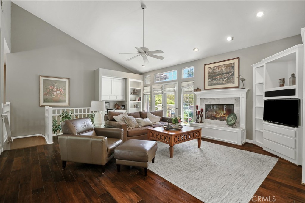 a living room with furniture a flat screen tv and a fireplace