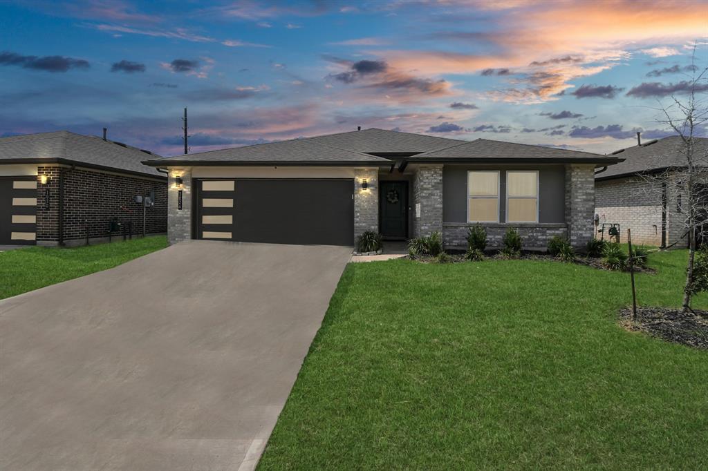 a front view of a house with a yard and garage