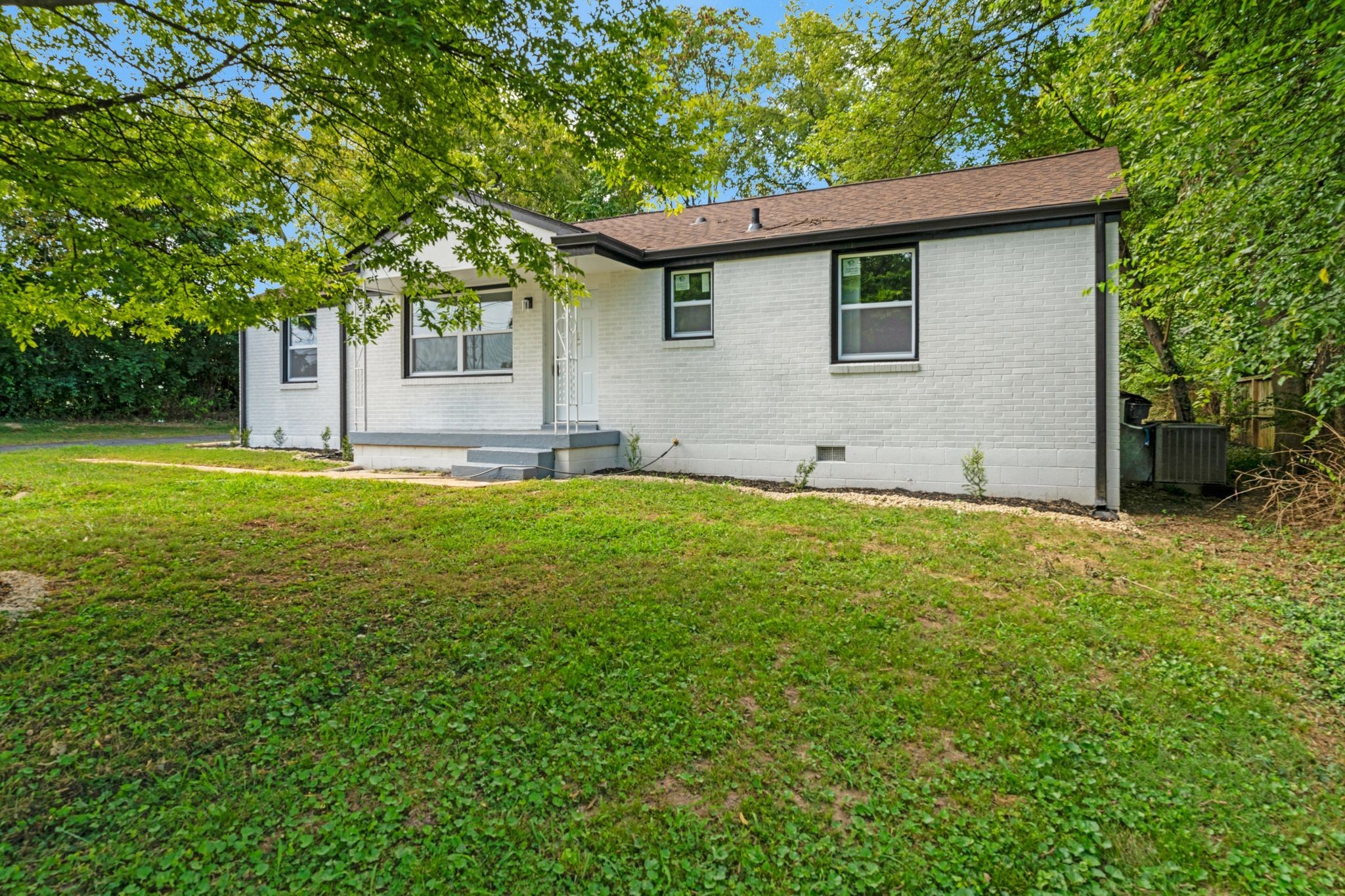 a view of a house with a yard and tree