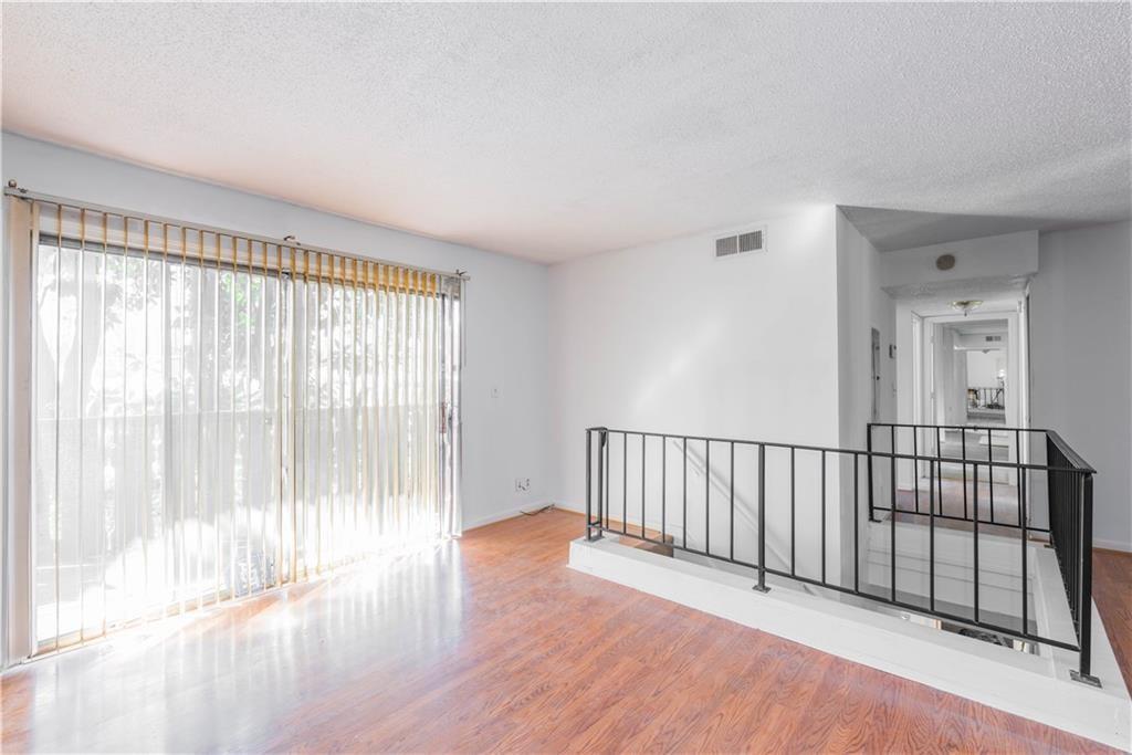 a view of a room with wooden floor and a window