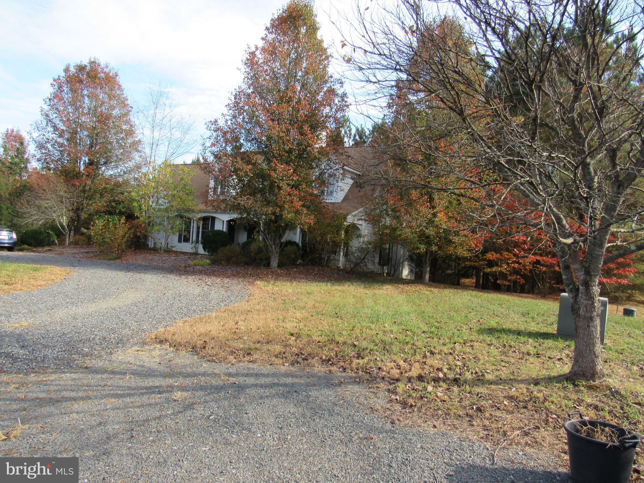 a view of a house with backyard and trees