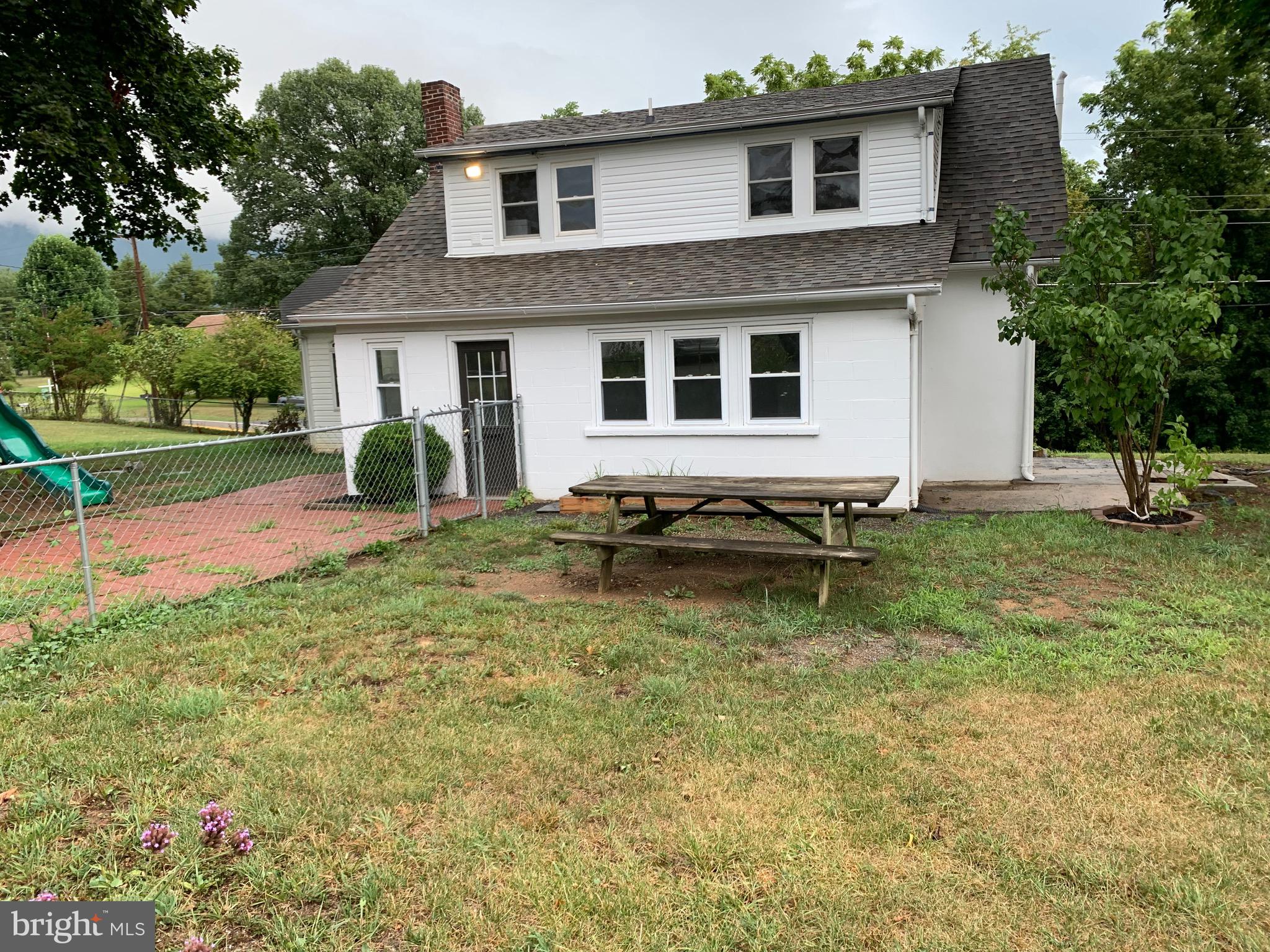 a backyard of a house with table and chairs