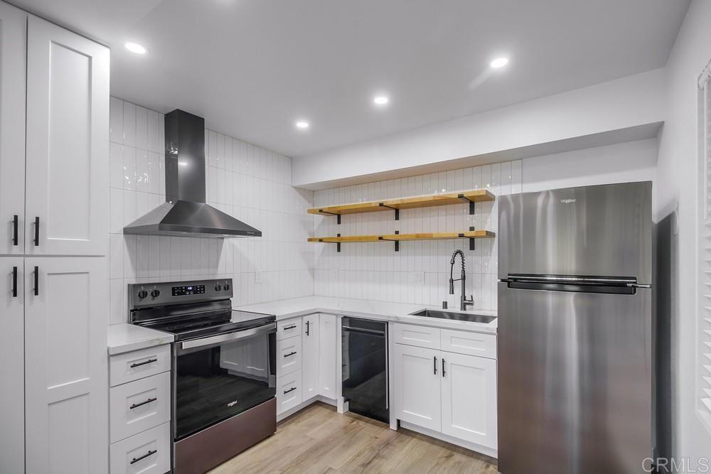 a kitchen with a refrigerator stove and white cabinets