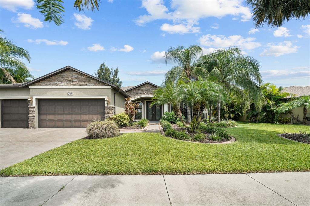 a front view of a house with a yard and potted plants