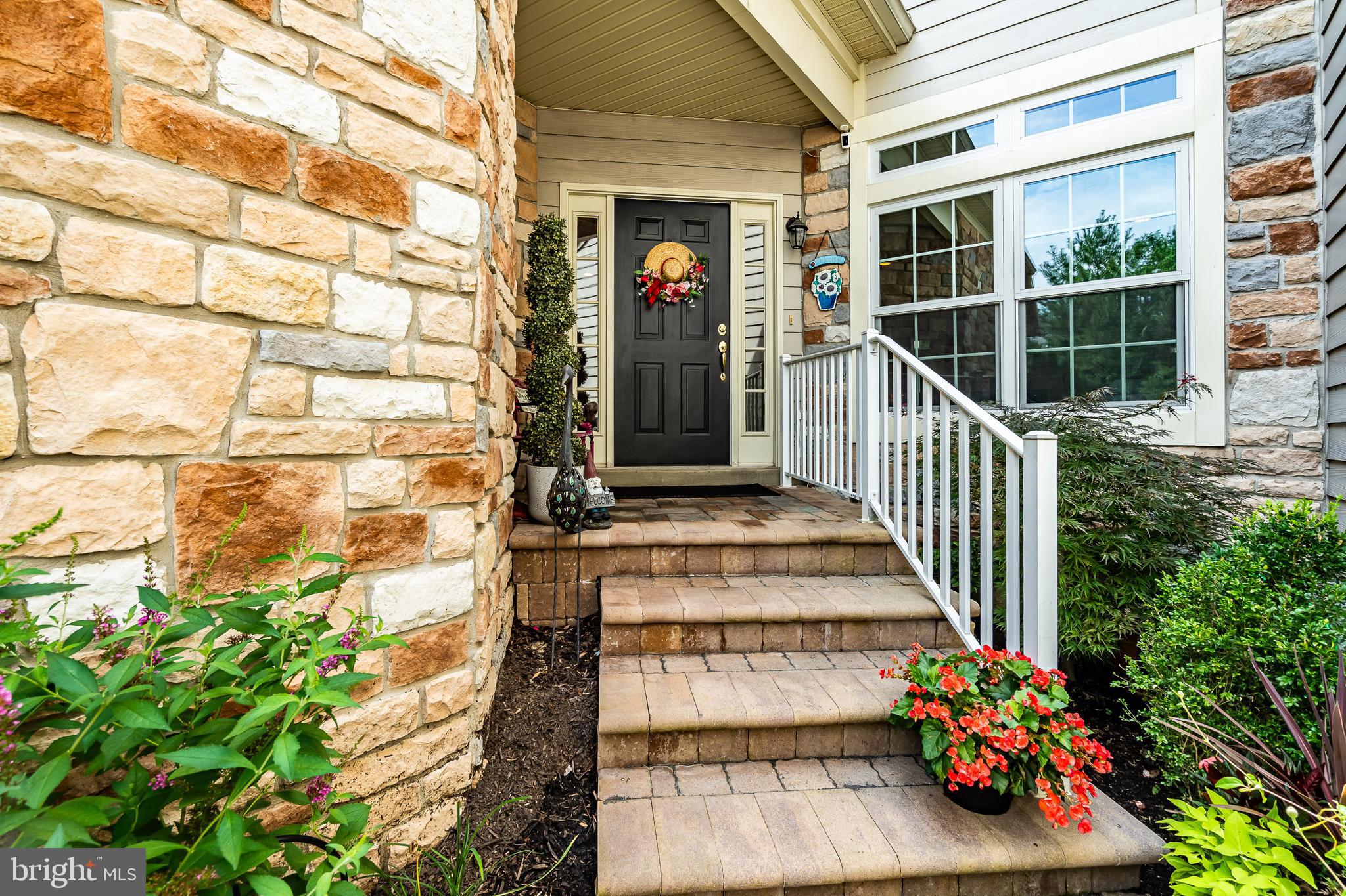 a view of a door of the house with flower plants