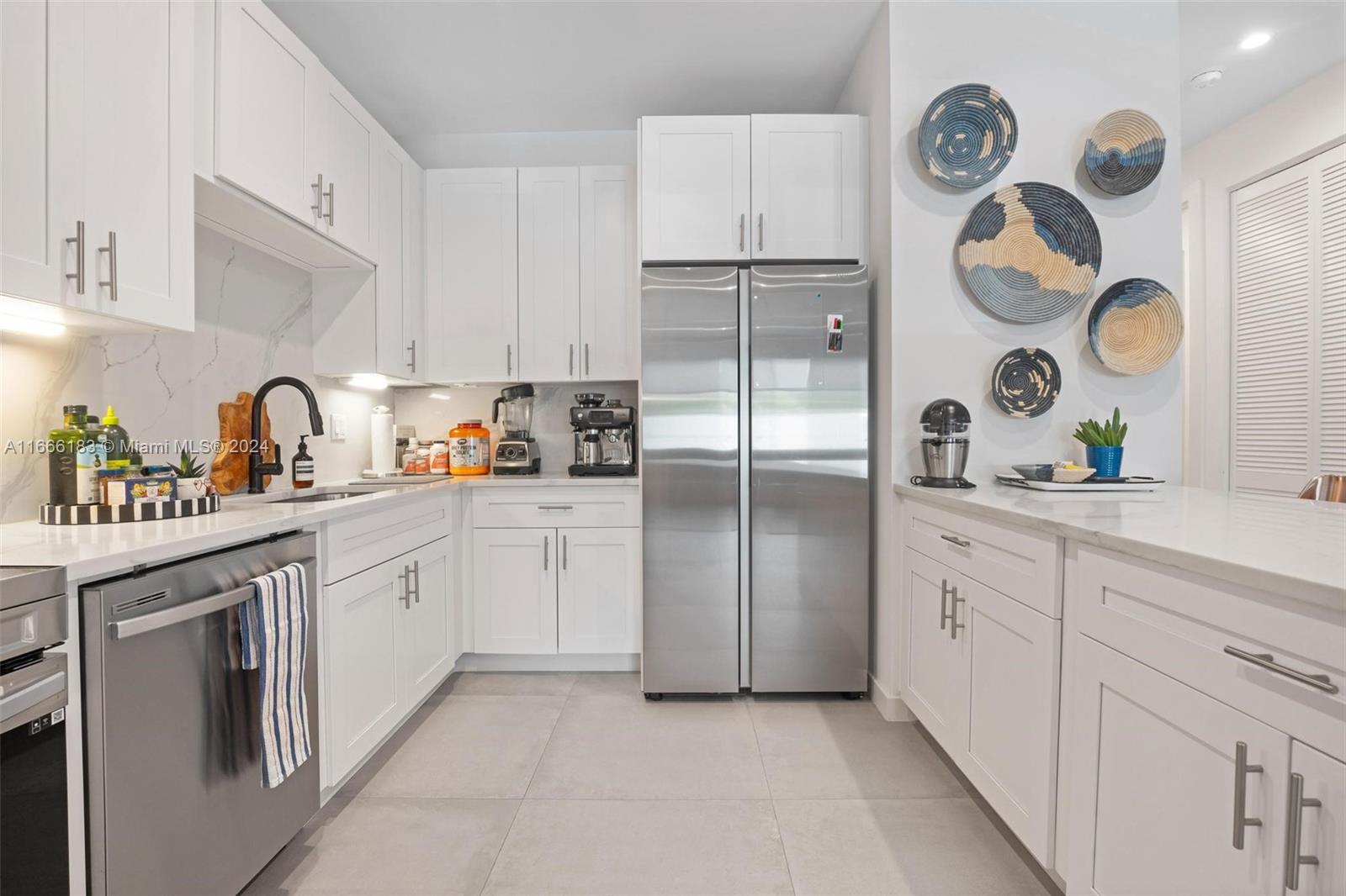 a kitchen with white cabinets and stainless steel appliances