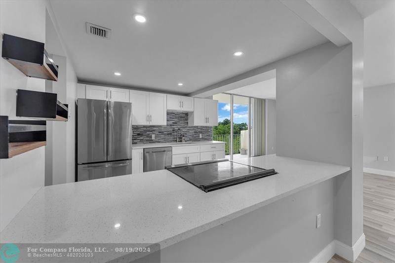 a kitchen with stainless steel appliances a refrigerator and a stove top oven