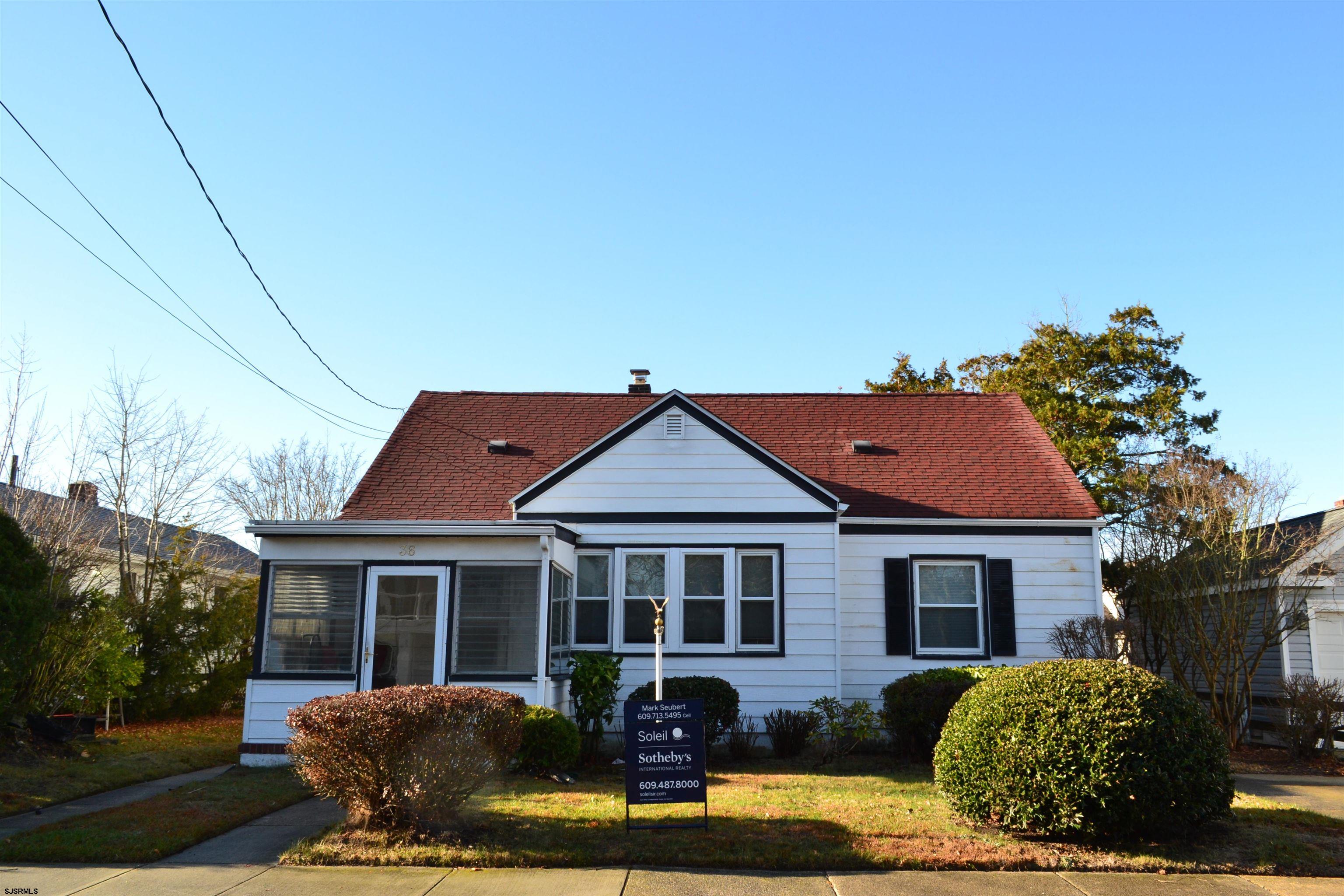 a front view of house with yard and trees in the background