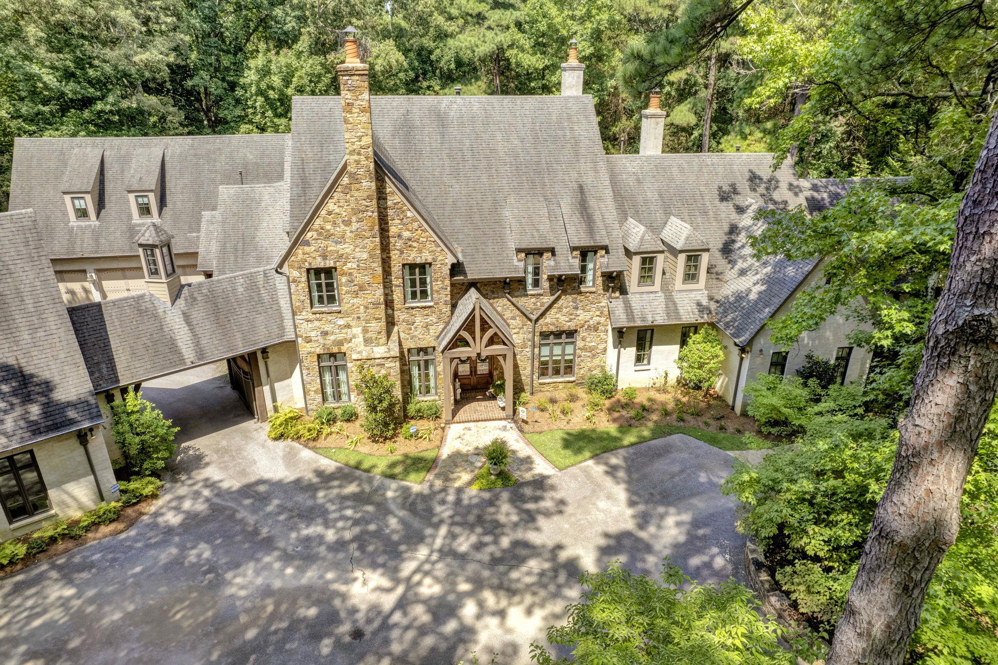 an aerial view of residential houses with outdoor space and trees