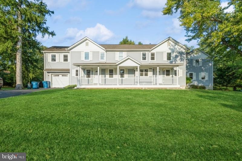 a front view of a house with a garden and trees