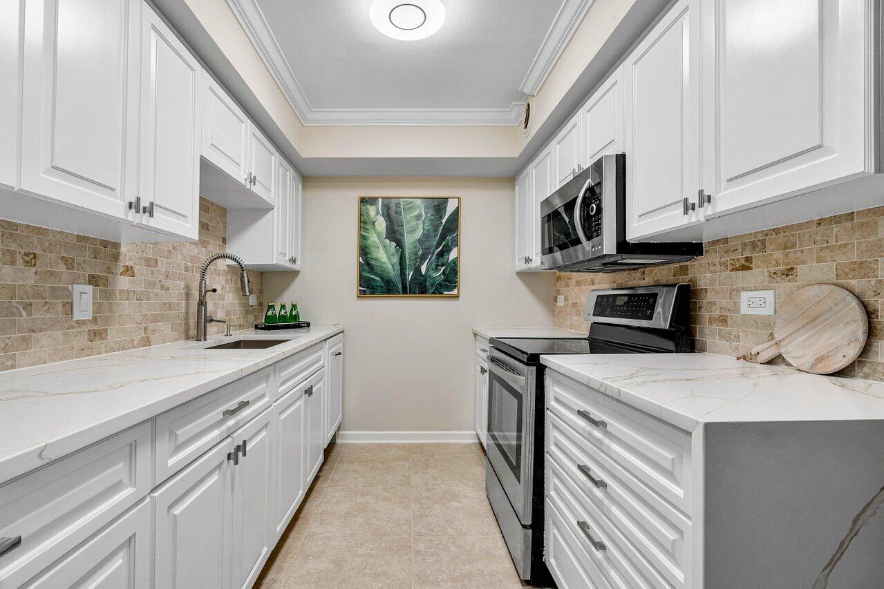 a kitchen with stainless steel appliances a sink a stove a microwave a sink and cabinets