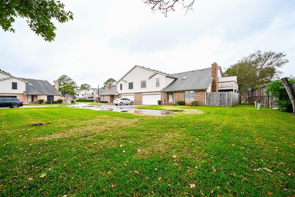 a view of a house with a big yard and large trees