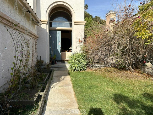 a view of a grey house with a small yard