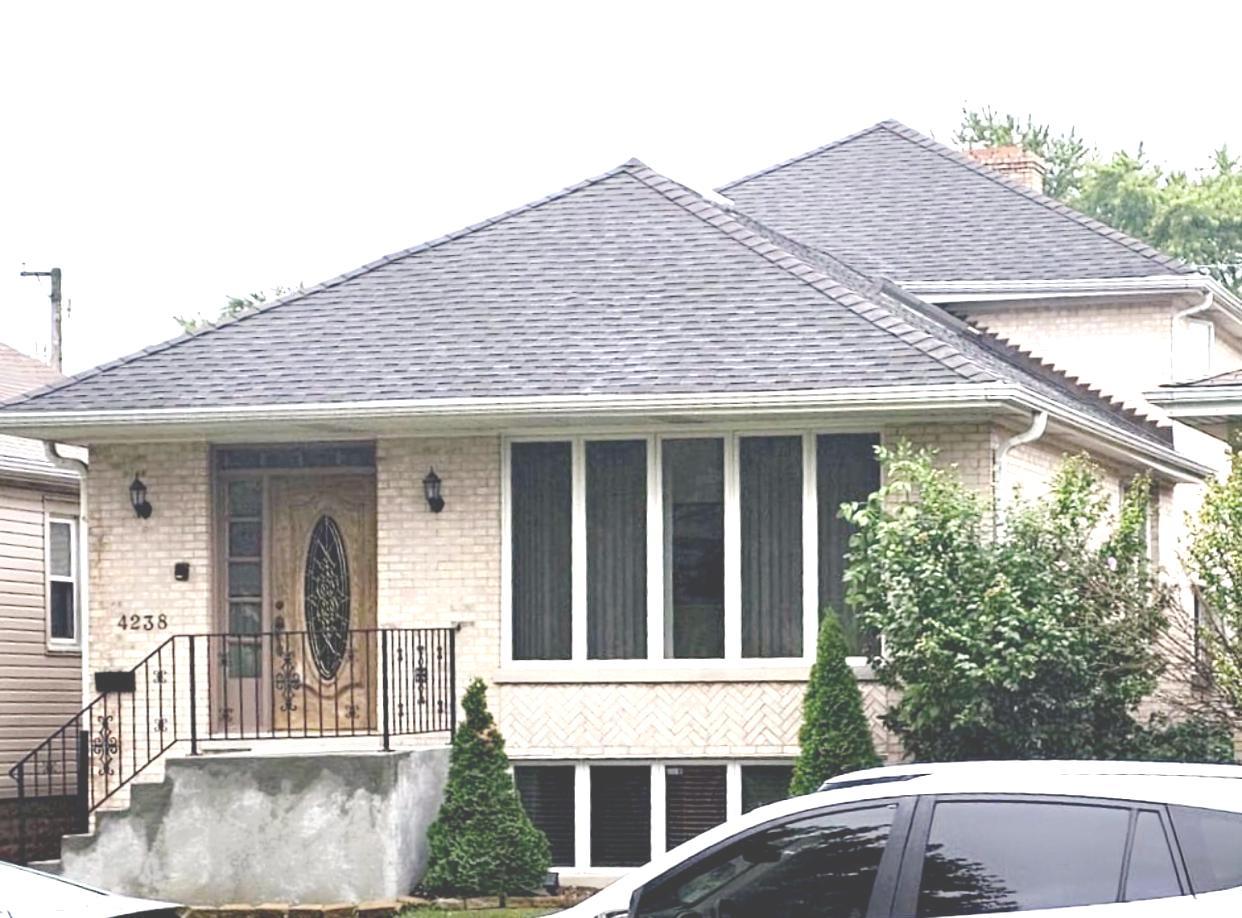 a view of a house with large windows and plants