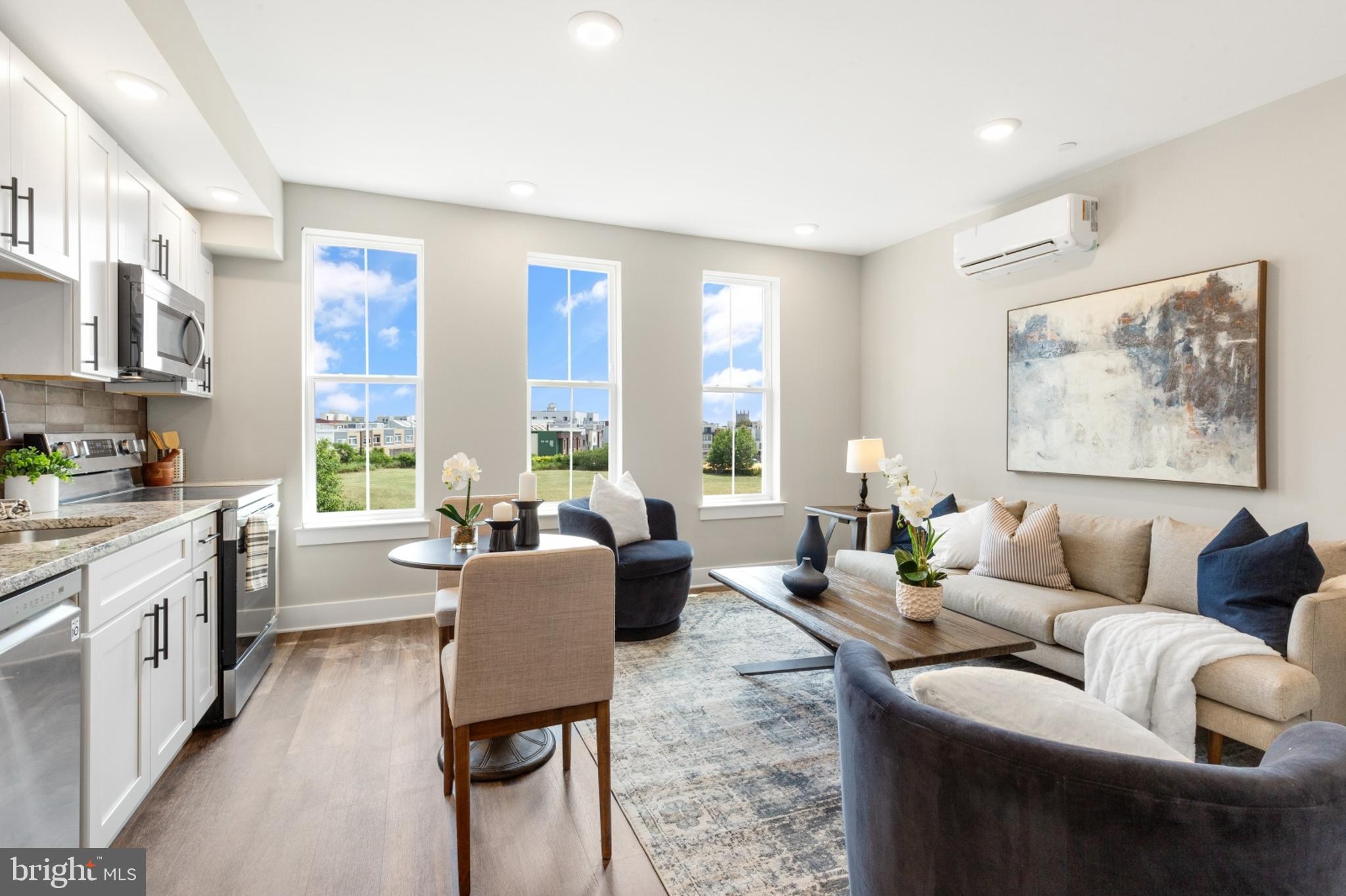 a living room with furniture large window and wooden floor