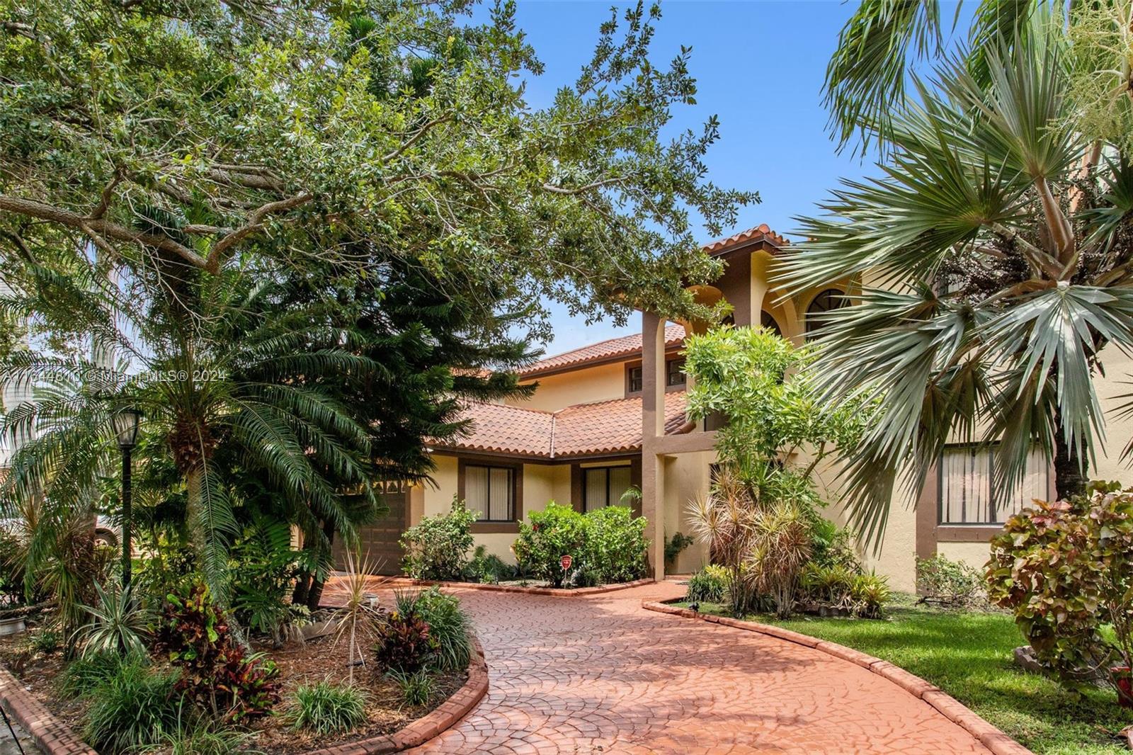 a front view of a house with a yard and potted plants