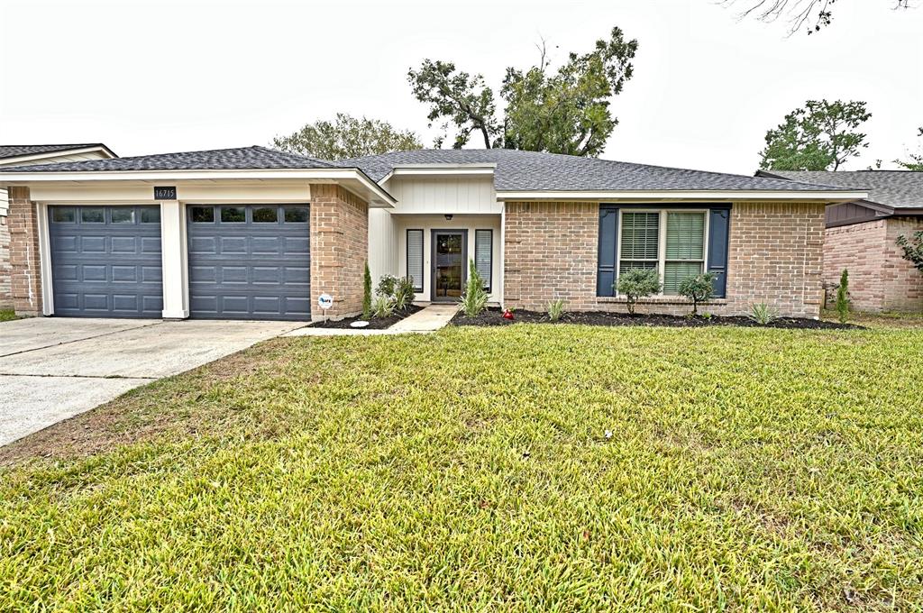 This is a single-story brick home featuring a two-car garage, a well-maintained lawn, and a welcoming entrance.