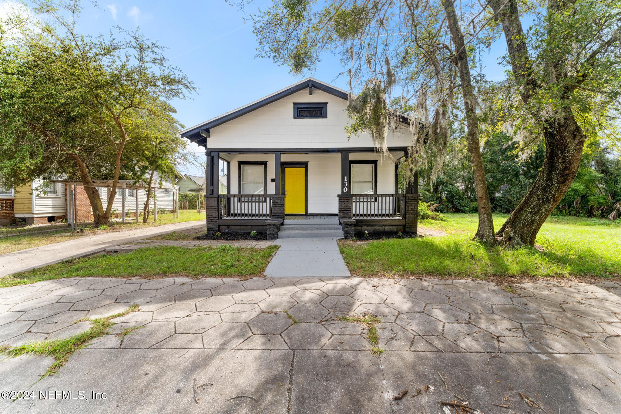 a front view of a house with a yard and an trees