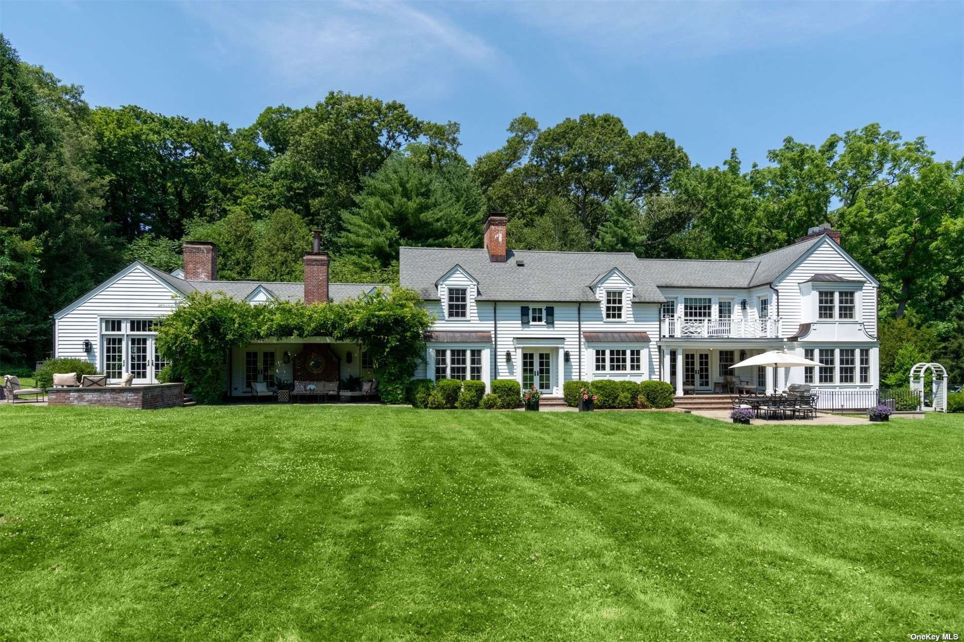 a front view of a house with a garden and trees