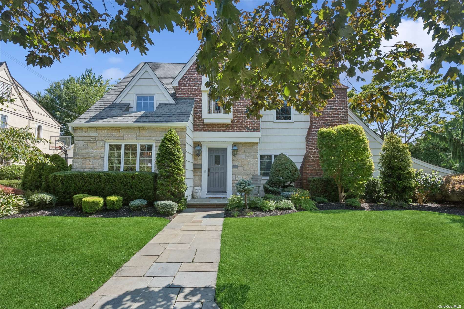 a front view of a house with a yard and trees