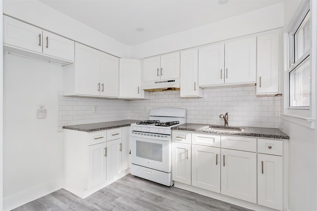 a kitchen with granite countertop white cabinets and white appliances