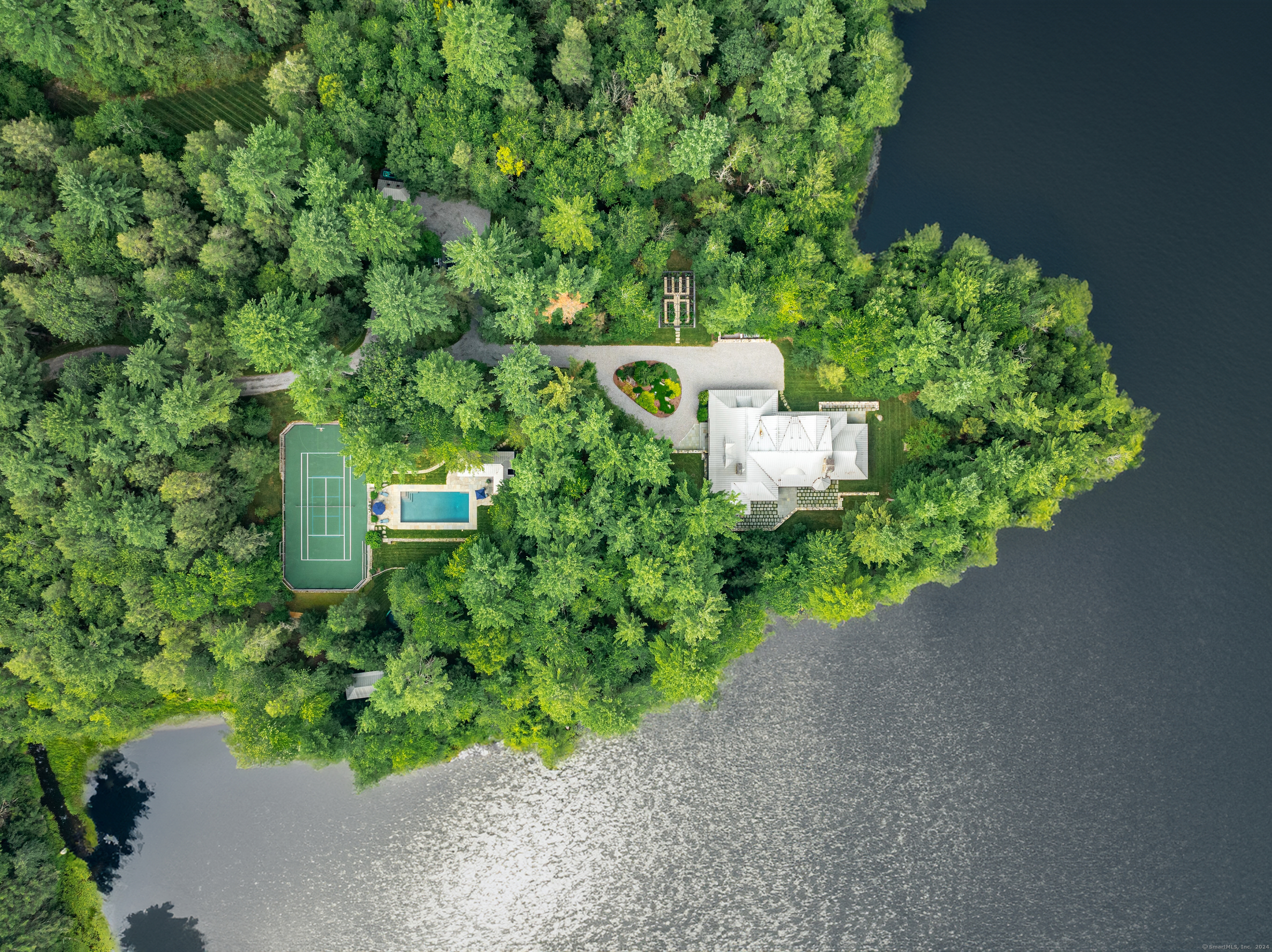 an aerial view of a house with a yard and lake view