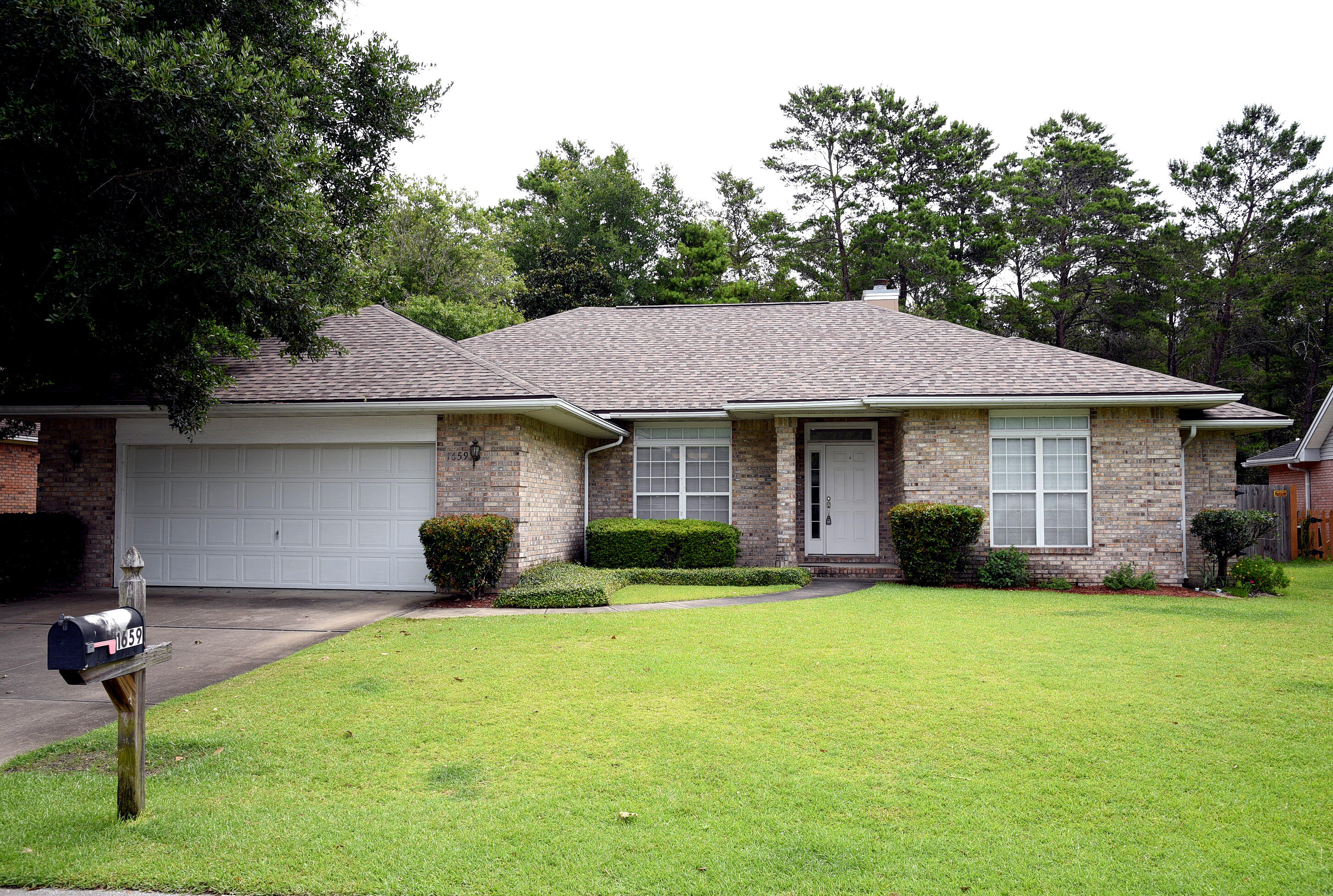 a front view of a house with a yard and trees