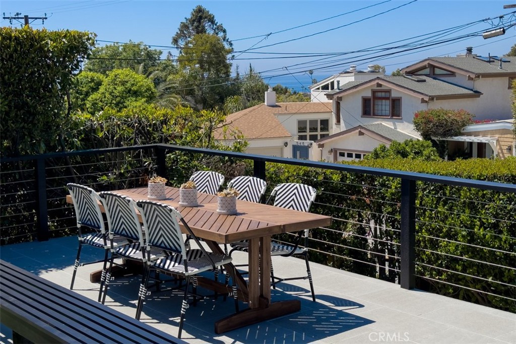 a balcony with wooden floor table and chairs