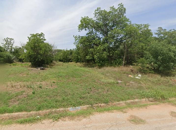 a view of a field with an trees in the background