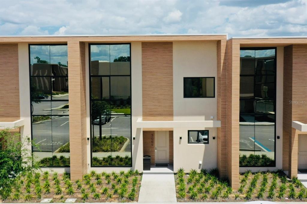 a view of a brick house with a large windows and plants