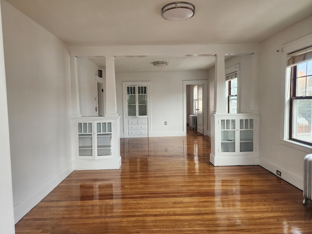 a view of a room with wooden floor and windows