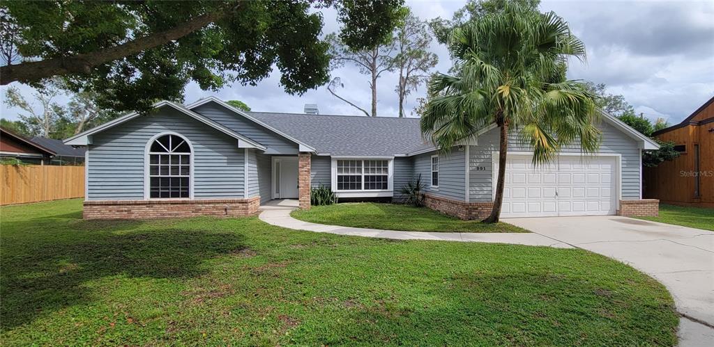 a front view of a house with a garden and yard