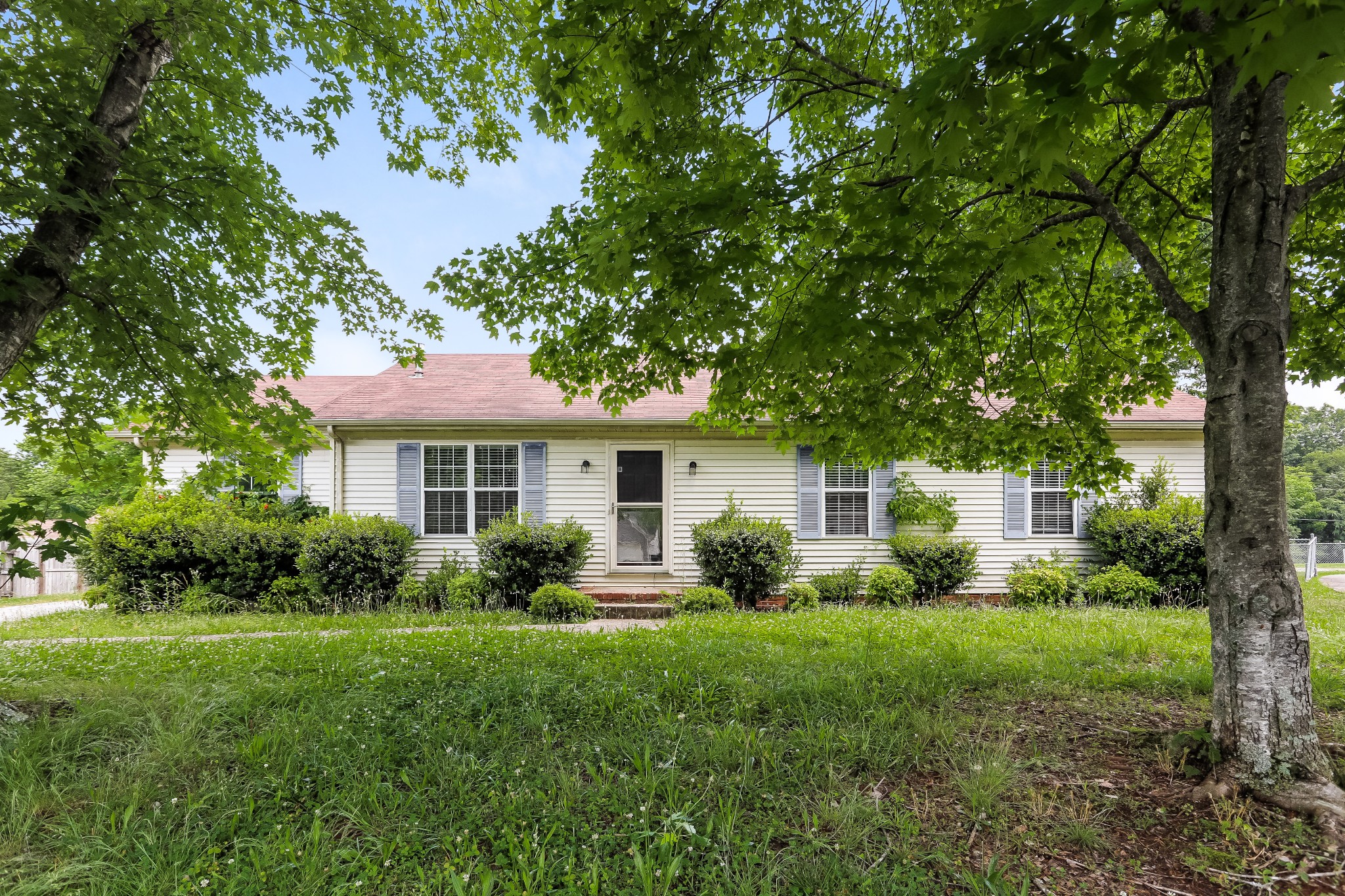 a front view of a house with porch and garden