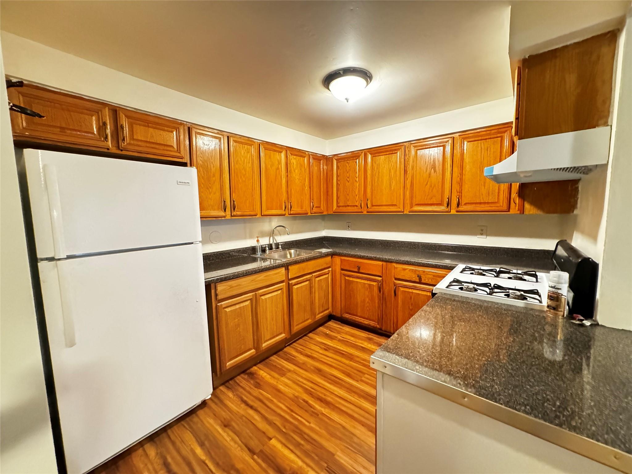 a kitchen with stainless steel appliances granite countertop a refrigerator sink and white cabinets